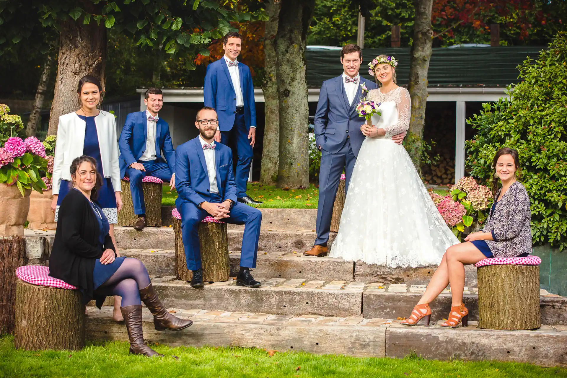 des mariés prennent la pose pour la photo officielle de leur mariage entourés de leurs garçons et demoiselles d'honneur.