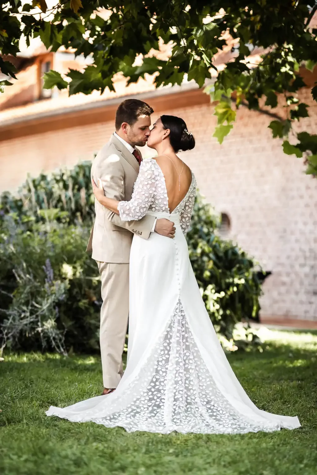 photo de mariage d'un couple posant dans la cour intérieure du Domaine des Cigognes