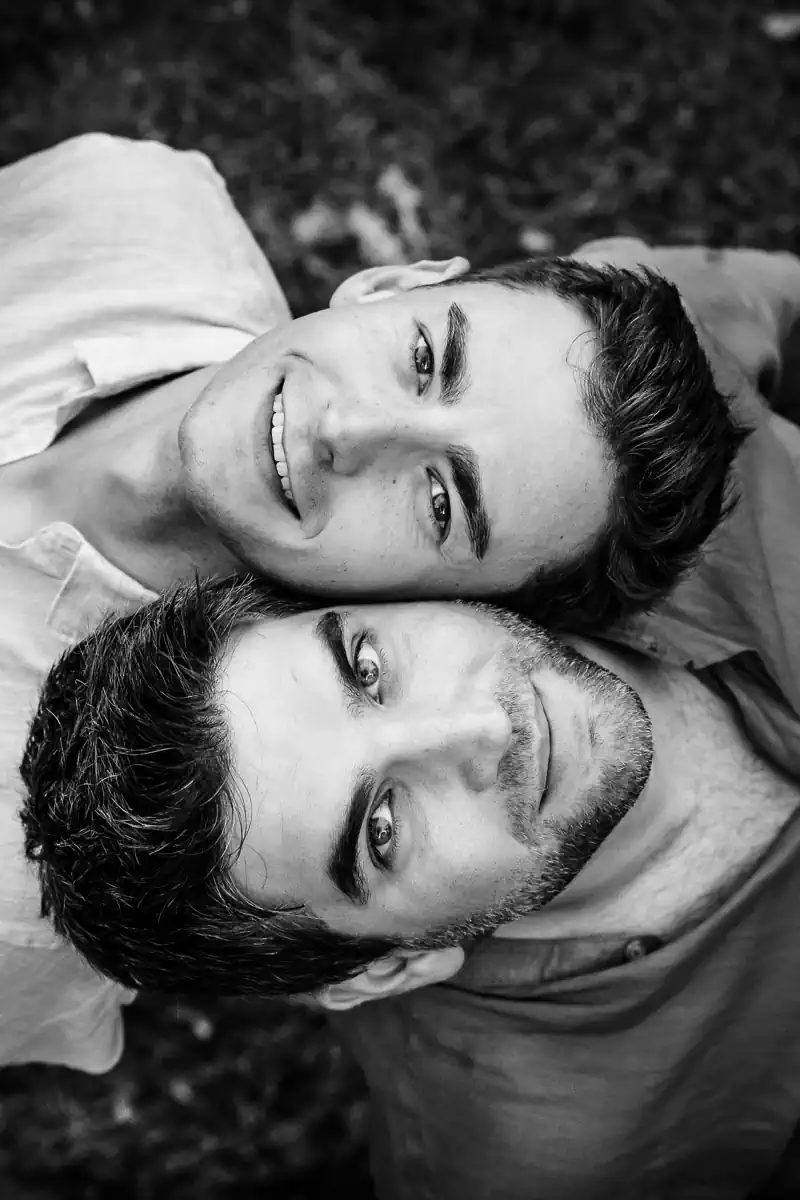 photo d'un couple d'hommes dos à dos regardant vers le ciel, les têtes posées côte à côte